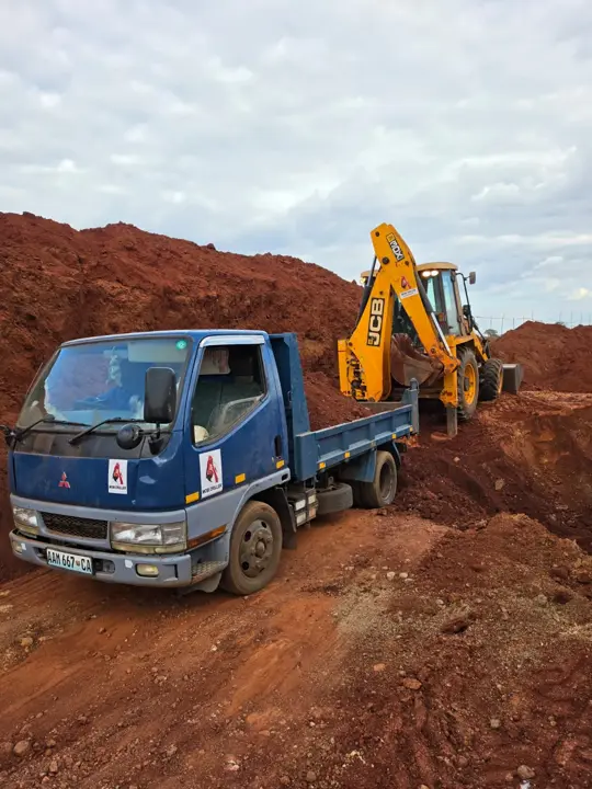 Camião basculante da Mobi Driller carregado por uma retroescavadora JCB