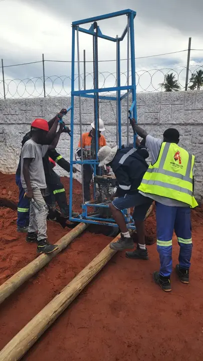 Equipa a trabalhar com uma sonda compacta num pátio murado